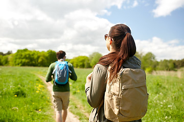 Image showing happy couple with backpacks hiking outdoors