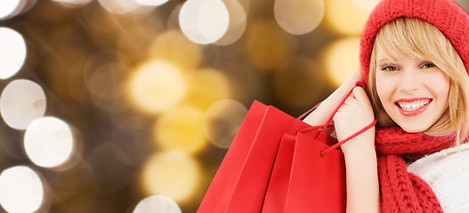 Image showing young happy woman with shopping bags over lights