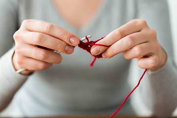 Image showing woman knitting with crochet hook and red yarn