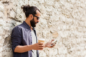 Image showing man with smartphone drinking coffee on city street