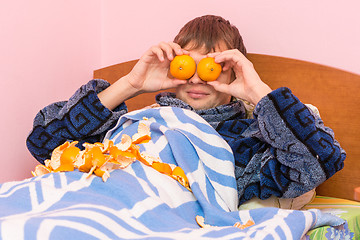 Image showing Man lying in bed and funny tangerines closed eyes