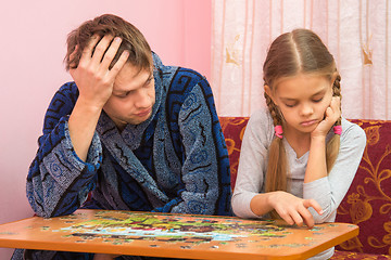 Image showing The Pope is tired looking at her daughter who collects a picture from puzzles