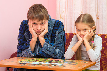 Image showing Dad and daughter could not assemble a picture from puzzles