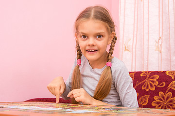 Image showing Girl collects a picture of the puzzle, and looked into the frame