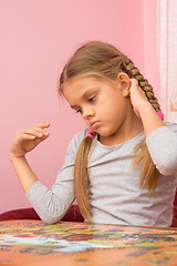 Image showing Girl thinks collecting picture of puzzles