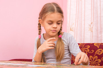 Image showing The girl thought collecting picture of puzzles