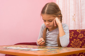 Image showing The girl does not know where to put the next puzzle element