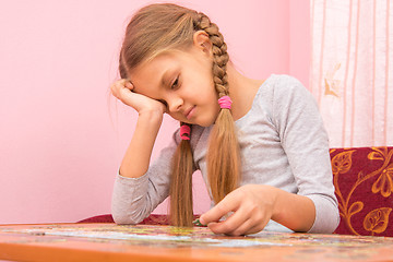 Image showing Girl little tired collecting picture of puzzles