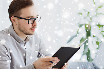 Image showing creative male worker with book at home office