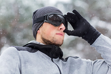 Image showing close up of sports man with ski goggles in winter