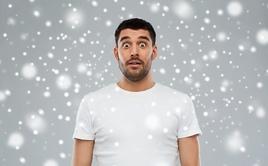 Image showing scared man in white t-shirt over snow