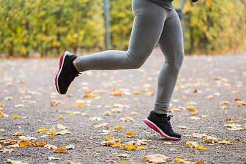 Image showing close up of young woman running in autumn park