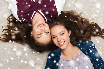 Image showing happy smiling pretty teenage girls lying on floor