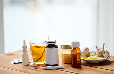 Image showing drugs, thermometer, honey and cup of tea on wood