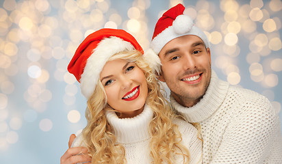 Image showing happy family couple in sweaters and santa hats