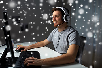 Image showing man in headset playing computer video game at home