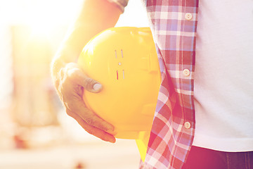 Image showing close up of builder hand holding hardhat outdoors