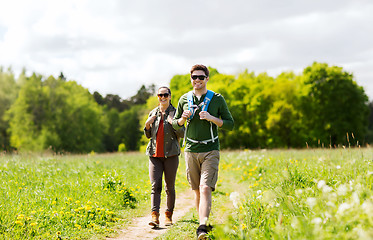 Image showing happy couple with backpacks hiking outdoors