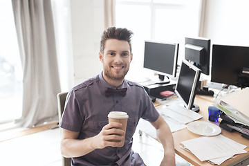 Image showing happy creative male office worker drinking coffee