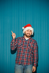 Image showing Smiling christmas man wearing a santa hat