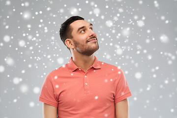 Image showing smiling man looking up over snow background