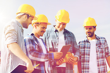 Image showing group of smiling builders with tablet pc outdoors