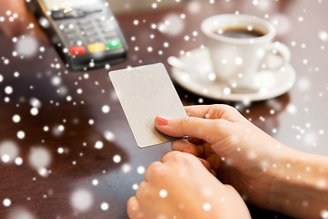 Image showing close up of hands with credit card reader at cafe