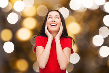 Image showing amazed laughing woman in red dress looking up