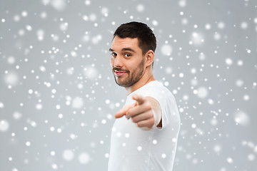 Image showing man pointing finger to you over snow background