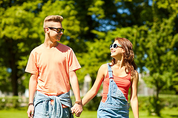 Image showing happy teenage couple walking at summer park