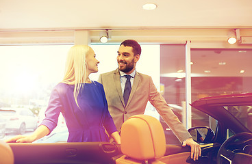 Image showing happy couple buying car in auto show or salon