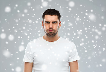 Image showing man with funny angry face over snow background