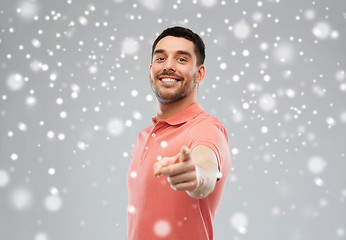 Image showing man pointing finger to you over snow background