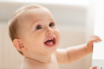 Image showing happy little baby boy or girl at home looking up