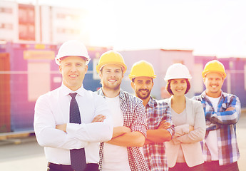 Image showing group of smiling builders in hardhats outdoors