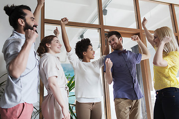 Image showing happy creative team celebrating victory in office