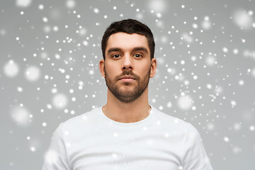 Image showing young man portrait over snow background