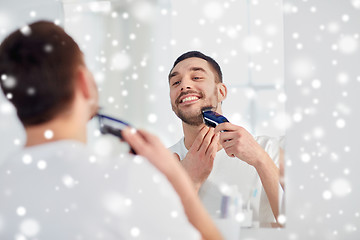 Image showing man shaving beard with trimmer at bathroom