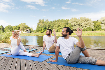 Image showing people making yoga in half lord of the fishes pose