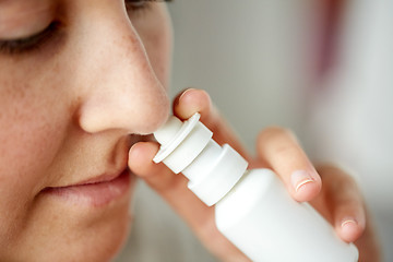 Image showing close up of sick woman using nasal spray