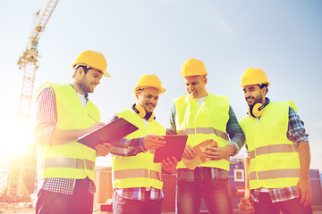 Image showing group of smiling builders with tablet pc outdoors