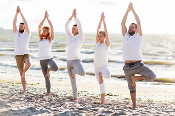 Image showing people making yoga in tree pose on summer beach