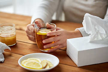 Image showing close up of ill woman drinking tea with lemon