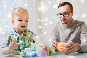 Image showing father and son playing with ball clay at home