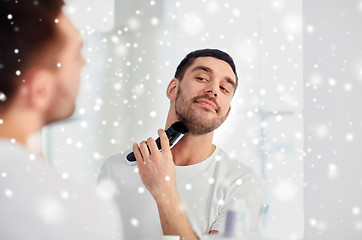 Image showing man shaving beard with trimmer at bathroom