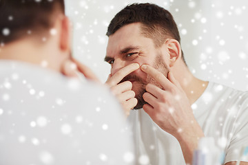 Image showing man squeezing pimple at bathroom mirror