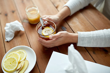 Image showing ill woman drinking tea with lemon and ginger