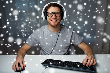 Image showing man in headset playing computer video game at home