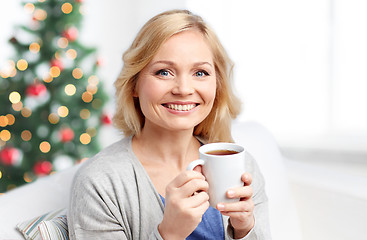 Image showing smiling woman with cup of tea or coffee at home