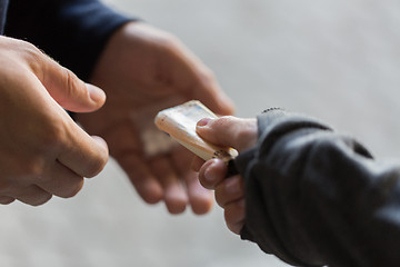 Image showing close up of addict buying dose from drug dealer